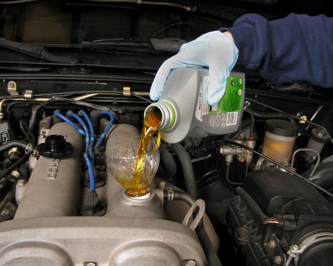 Image of oil being topped up on a Car