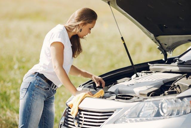 Image of a Lady Checking the engine on her Car