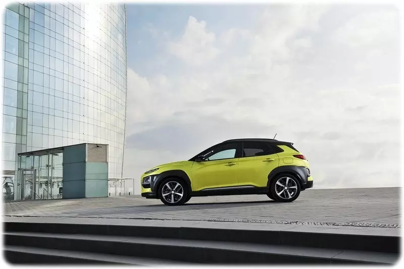 2018 Hyundai Kona in Acid Yellow, in fornt of a large modern glass building