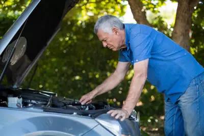 Person checking car engine