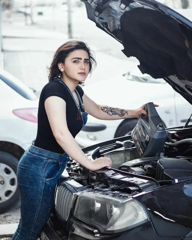 Image of a lady topping up her car engine oil