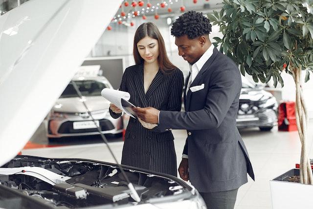 Image of a Man & Woman Inspecting a Car